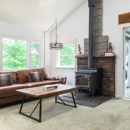 Relax and recharge in the living room with a comfy leather sofa, smart TV, and charming fireplace (please note it's decorative only).