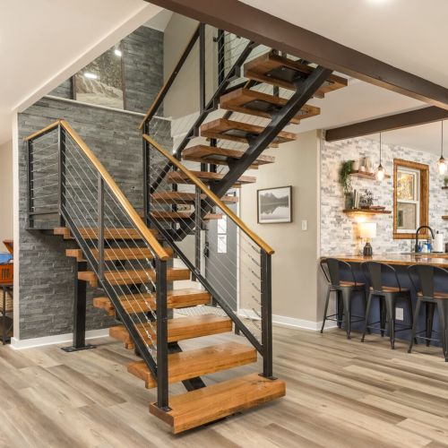 A modern staircase with rustic charm connects the home’s two levels, blending function with warm design details.