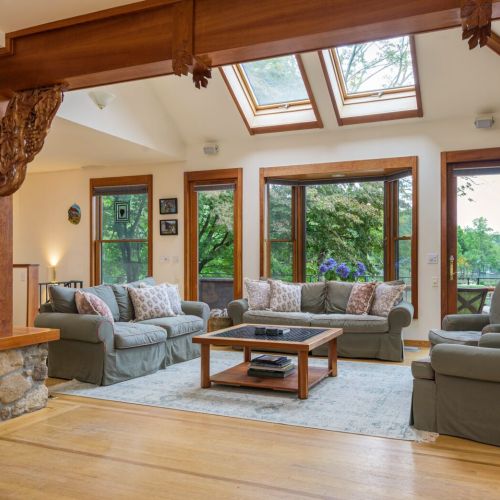 Surrounded by windows and natural light, this cozy living room invites you to unwind with a good book or good company.