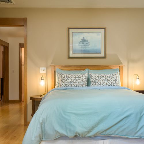 Sunlight, serenity, and space to unwind — this lakeside bedroom features a comfy full bed, deck access, and a desk for moments of quiet focus.
