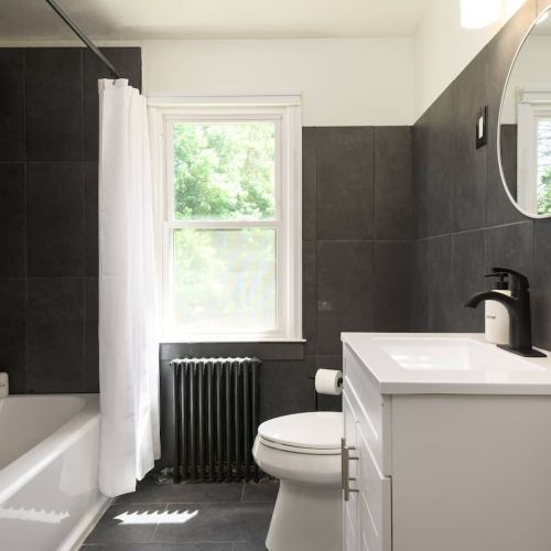 The upstairs bathroom makes a statement with its deep, modern tones - a stylish space to start or end your day.