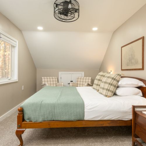 Your private retreat awaits - this upstairs king bedroom offers peaceful lake views, soft lighting, and a cozy corner to relax and recharge.