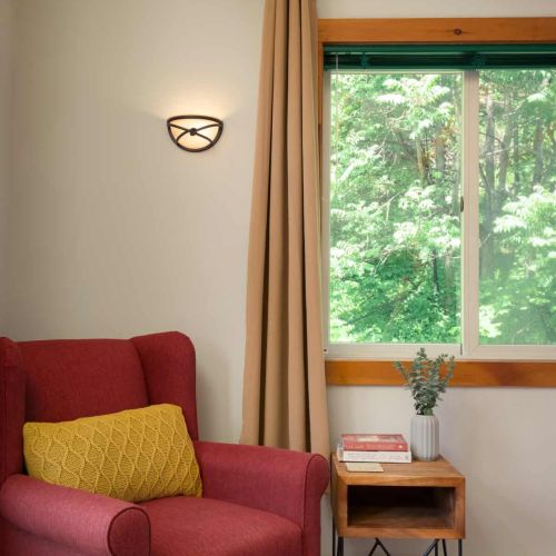 A comfortable reading chair offers the perfect spot to relax and take in the wooded views.