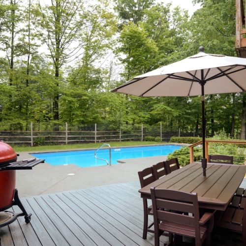 Swim, sizzle, and savor - this backyard is your summer sanctuary, complete with a pool, grill, and al fresco dining on the deck.