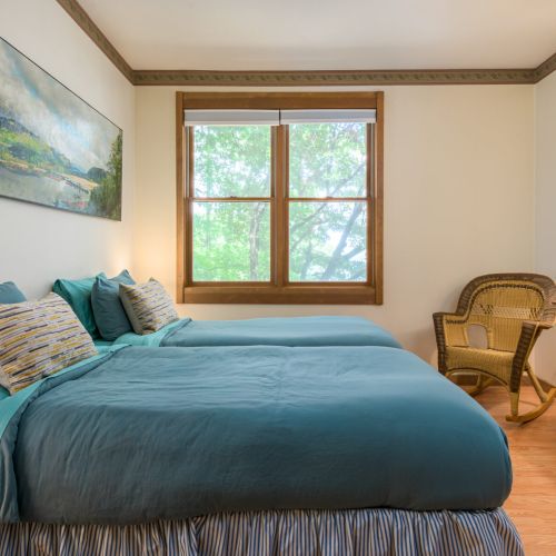 Two comfy beds and serene water views make this lower-level bedroom a peaceful spot to rest and recharge.