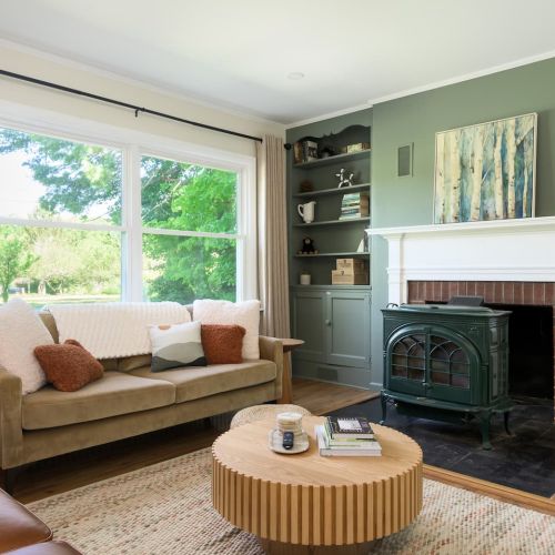 Gather around the heart of the home - the cozy living room features a charming fireplace (available for use from November - March). Please note the suede 3 seater couch has been changed out for a larger 2 seater.