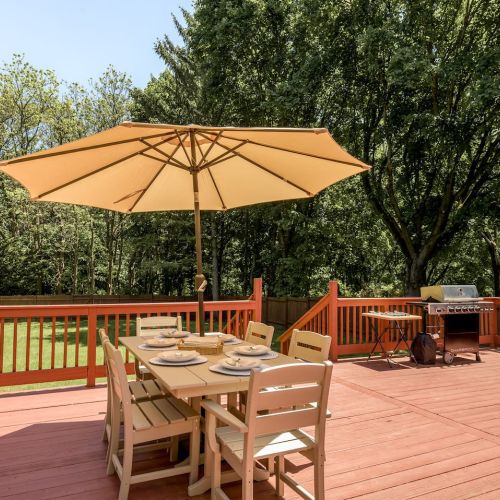 Enjoy meals al fresco at the outdoor dining table, just steps from the kitchen and grill - perfect for long summer evenings and casual cookouts.