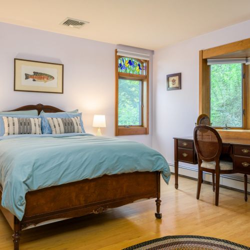 Comfy and convenient — this full bed sits just steps from the yard, with direct outdoor access for easy lake day starts.