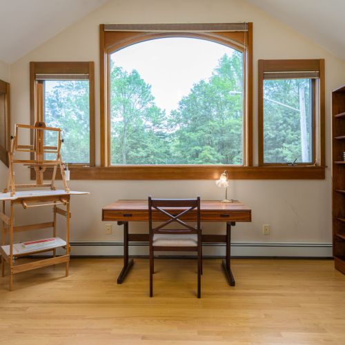 A dreamy spot to write, reflect, or catch up — this tucked-away desk nook is framed by oversized windows and calming lake views.