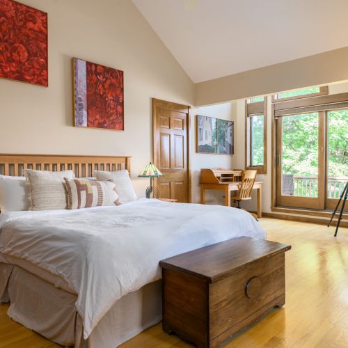 Spacious, serene, and filled with light — this primary suite features a king bed, vaulted ceilings, a desk for quiet moments, and a private deck with stunning lake views.