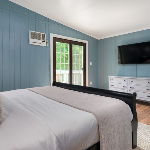 Spacious and sunlit, the upstairs bedroom invites you to unwind with a king bed, 50 inch Smart TV, and all the comforts of home. Please note this bedroom does not contain curtains or blackout shades - all you see is woods outside.