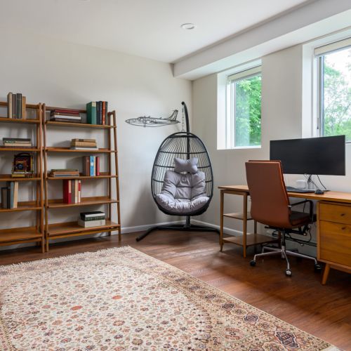 A dreamy nook for work or winding down - this light-filled office features a bookshelf for inspiration and a hanging chair made for mid-day pauses.