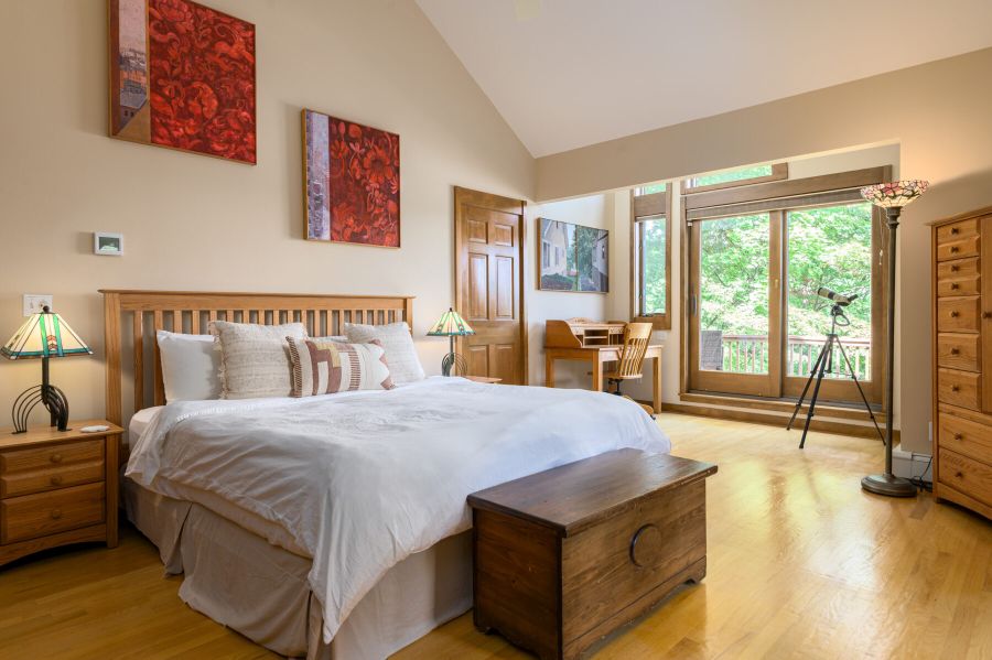 Spacious, serene, and filled with light — this primary suite features a king bed, vaulted ceilings, a desk for quiet moments, and a private deck with stunning lake views.