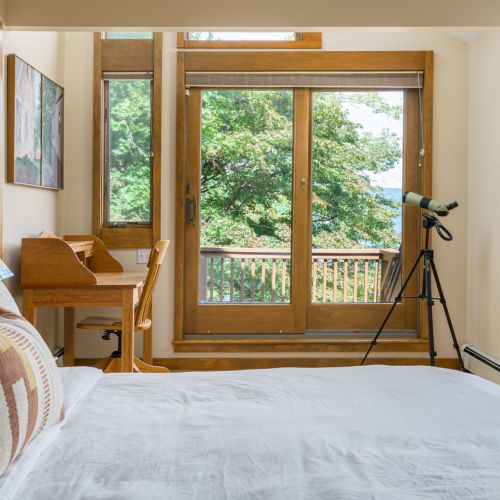 With soaring ceilings, lake views, and direct deck access, this peaceful primary bedroom blends comfort and calm in all the right ways.