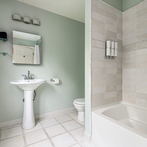 A clean and classic full bath with a tub-shower combo - perfect for a relaxing soak or a quick rinse after a day of exploring.