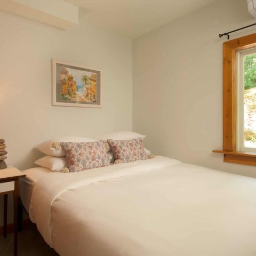 Natural light and calming woodland views create a peaceful retreat in the downstairs queen bedroom.