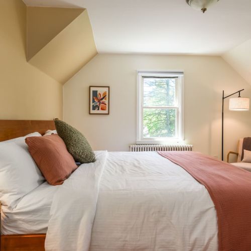 The spacious primary bedroom features a plush king bed, blackout shades, and soft lighting for a restful night’s sleep - whether you're turning in early or sleeping in late.