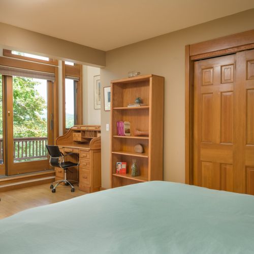 Wake up to lake views and step right onto the deck — this upstairs retreat offers a full bed, peaceful vibes, and a cozy desk nook for journaling or checking in.