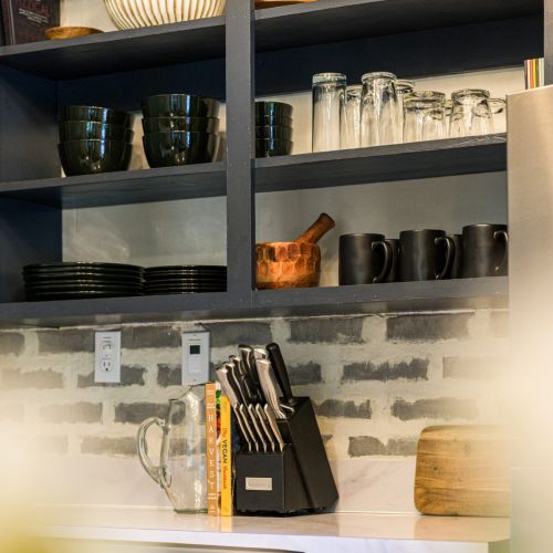 Open shelving adds charm and function - stocked with everyday dishes and thoughtful touches that make the kitchen feel like home.