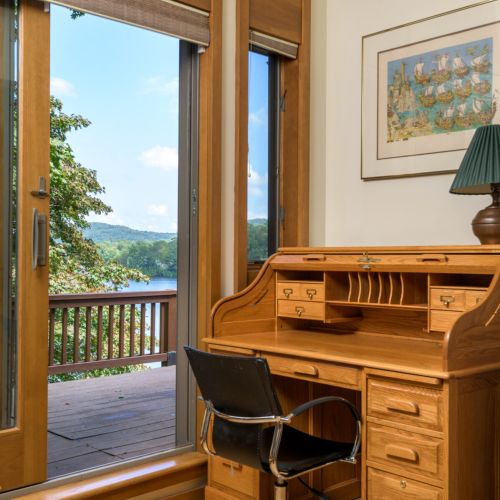 Work (or daydream) with a view — this desk setup overlooks the lake and opens right onto the private upstairs deck.