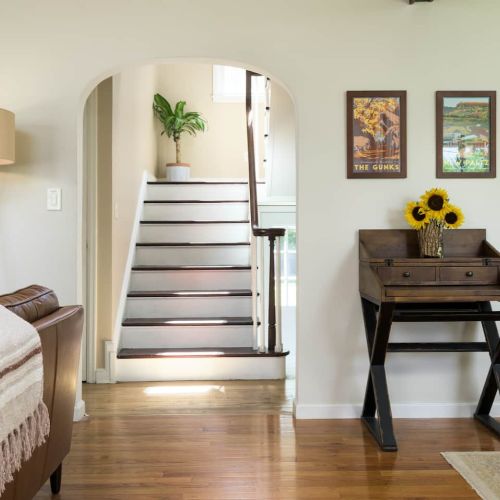 The rounded view from the entryway captures the staircase’s vintage lines and offers a peek into the living area beyond. It sets the tone for a stay that blends classic character with comfort.